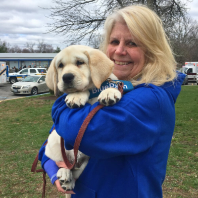Cathy Capasso poses with lab puppy from BluePath