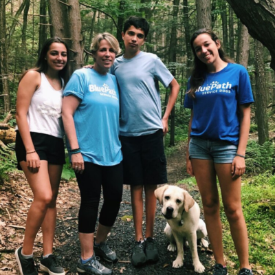 Family hiking with service dog