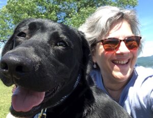 black lab puppy smiling with adult woman
