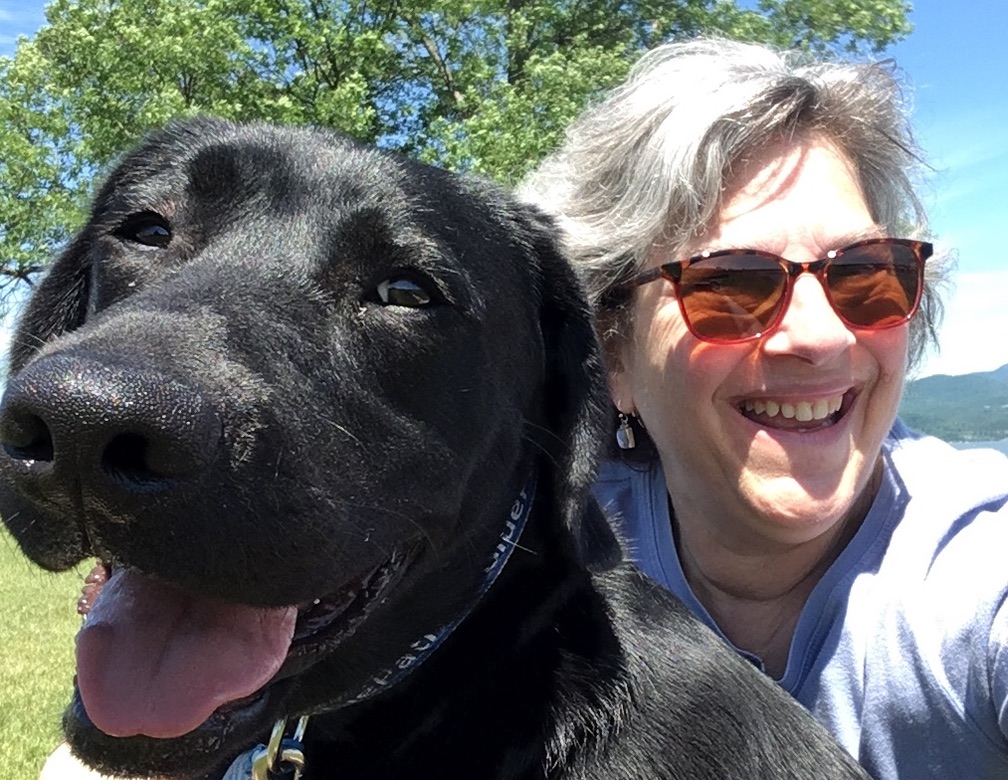 black lab puppy smiling with adult woman